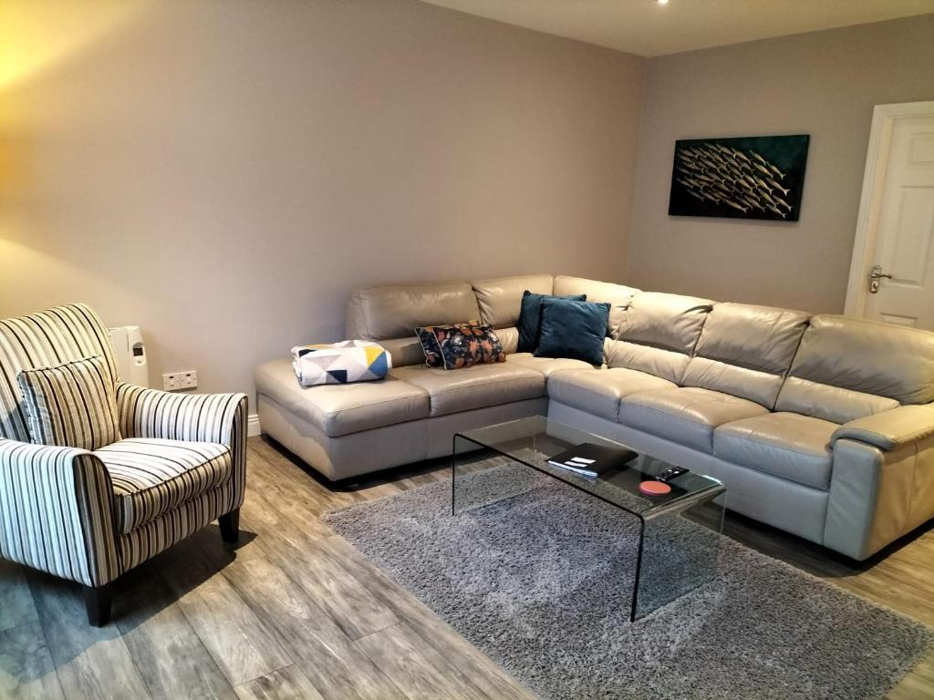 sala de estar con sofá y silla en Dolmen Apartment Carlingford Lough,Omeath en Ó Méith