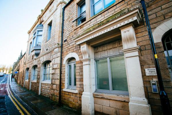 a brick building with windows on the side of a street at 'Woodbury' at stayBOOM in Lancaster