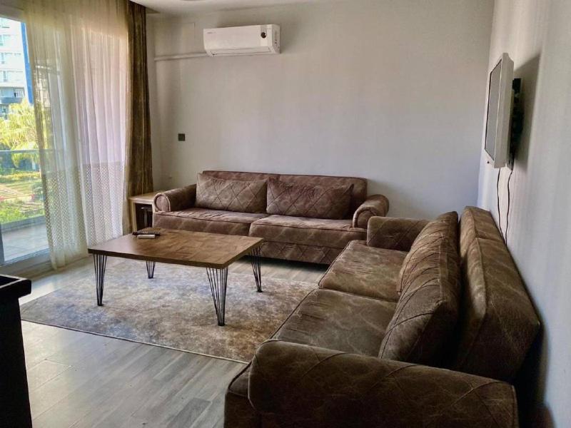 a living room with a couch and a coffee table at Palmiye Gold in Çiftlikköy