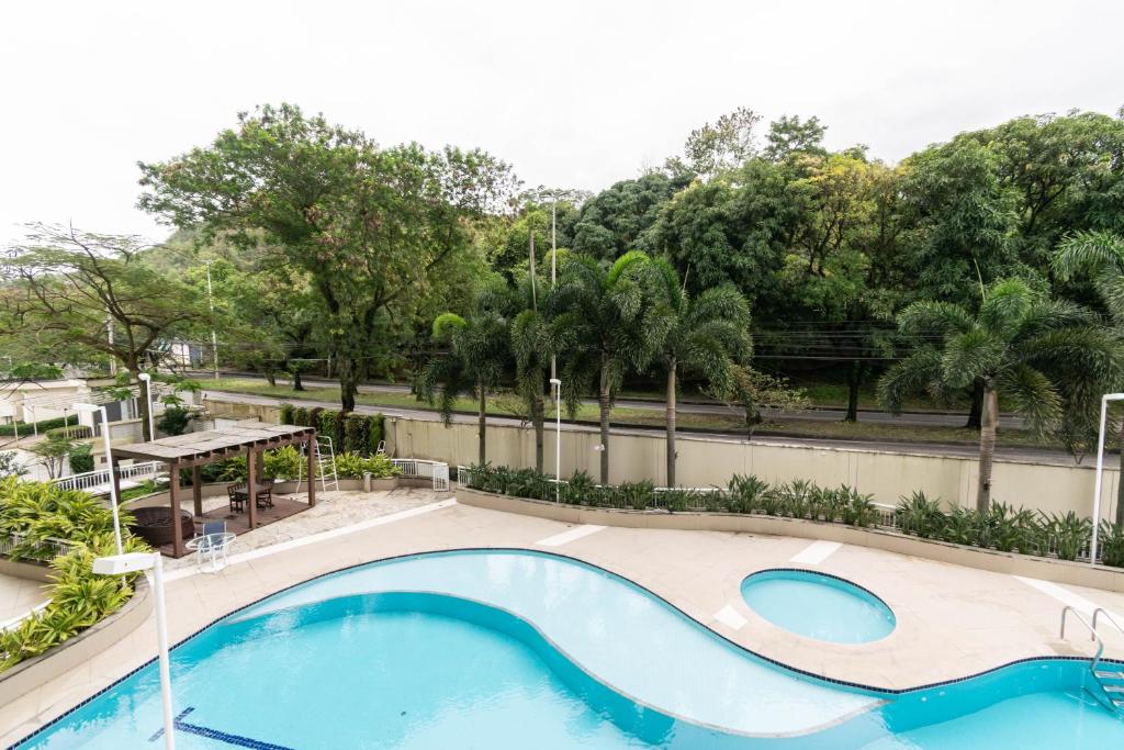 a swimming pool with a picnic table and trees at Rio stay flat rio centro, jeunesse, globo, rock in rio in Rio de Janeiro