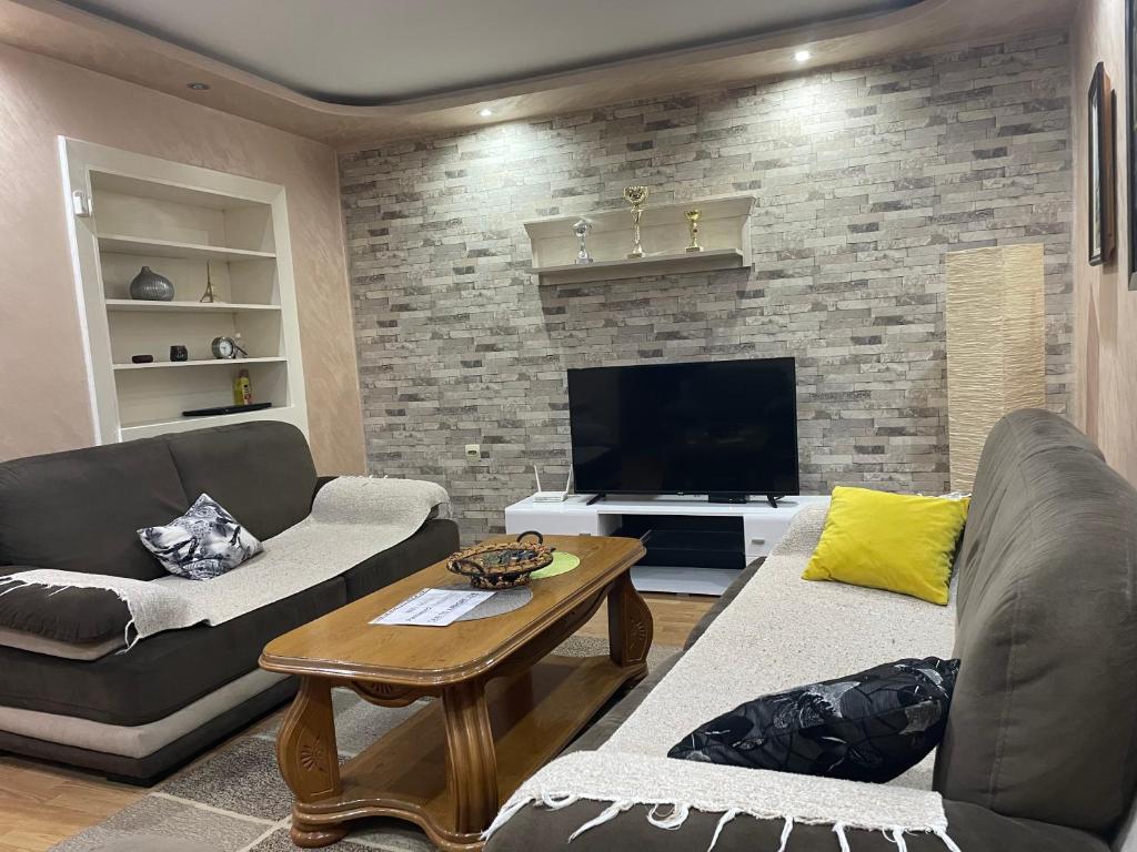 een woonkamer met 2 banken en een open haard bij Max Apartments in Podgorica