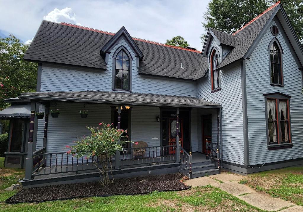 a gray house with a porch with a balcony at The Carson House Bed & Breakfast in Pittsburg