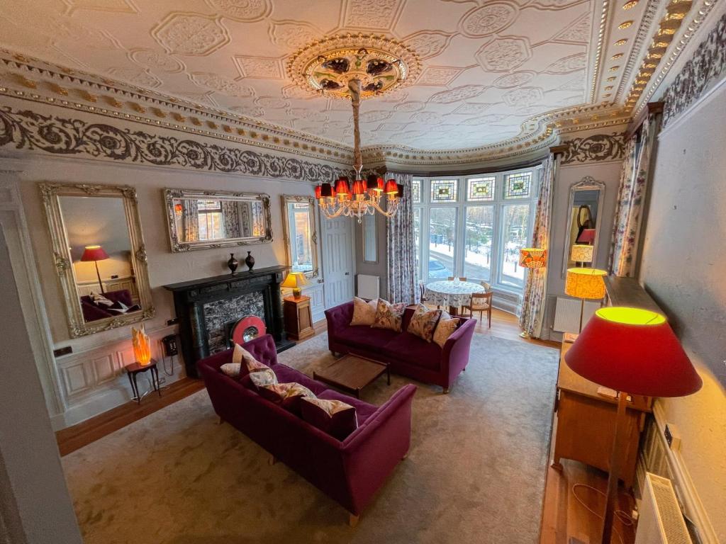 a living room with purple furniture and a chandelier at 1 Bed Character Filled Glasgow Apartment in Glasgow