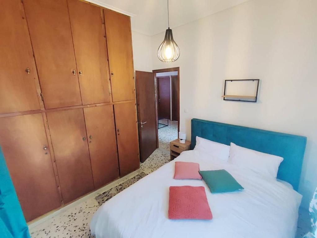 um quarto com uma cama branca e armários de madeira em Akrokorinthos View House em Kórinthos