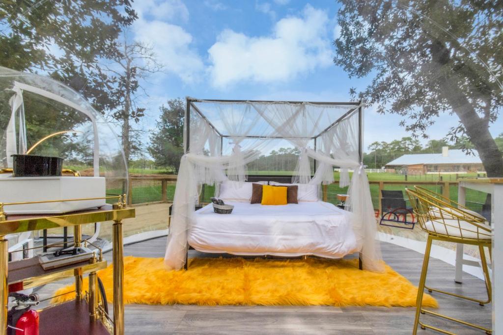 a canopy bed on a deck with a table at Bespoke Outdoor Bubbles in Cleveland