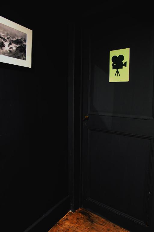 a door with a sign on it in a black room at Eau Berges in Vicdessos