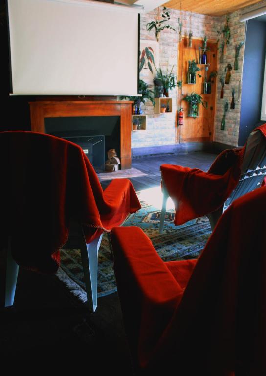 a living room with red chairs and a flat screen tv at Eau Berges in Vicdessos