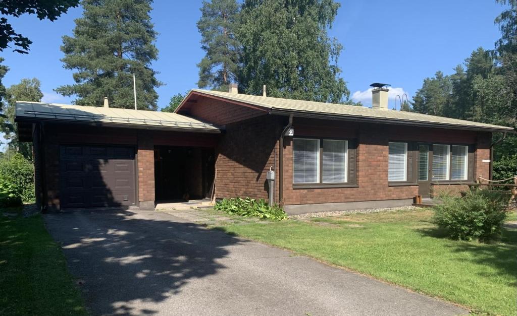 a brick house with a garage and a driveway at Omakotitalo 100m2, 3 makuuhuonetta Joensuu in Joensuu