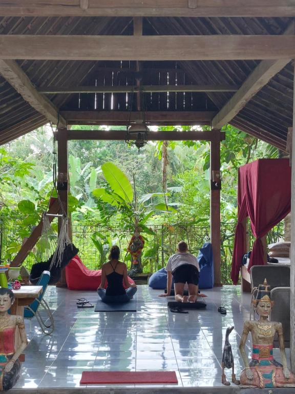 a group of people sitting on the floor in a yoga class at Didu's Homestay Bed & Breakfast in Banyuwangi