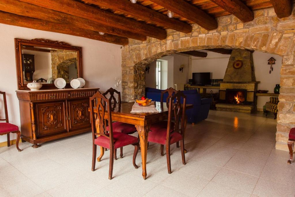 uma sala de jantar com uma mesa e uma lareira em Masia Can Castanyola em Marganell