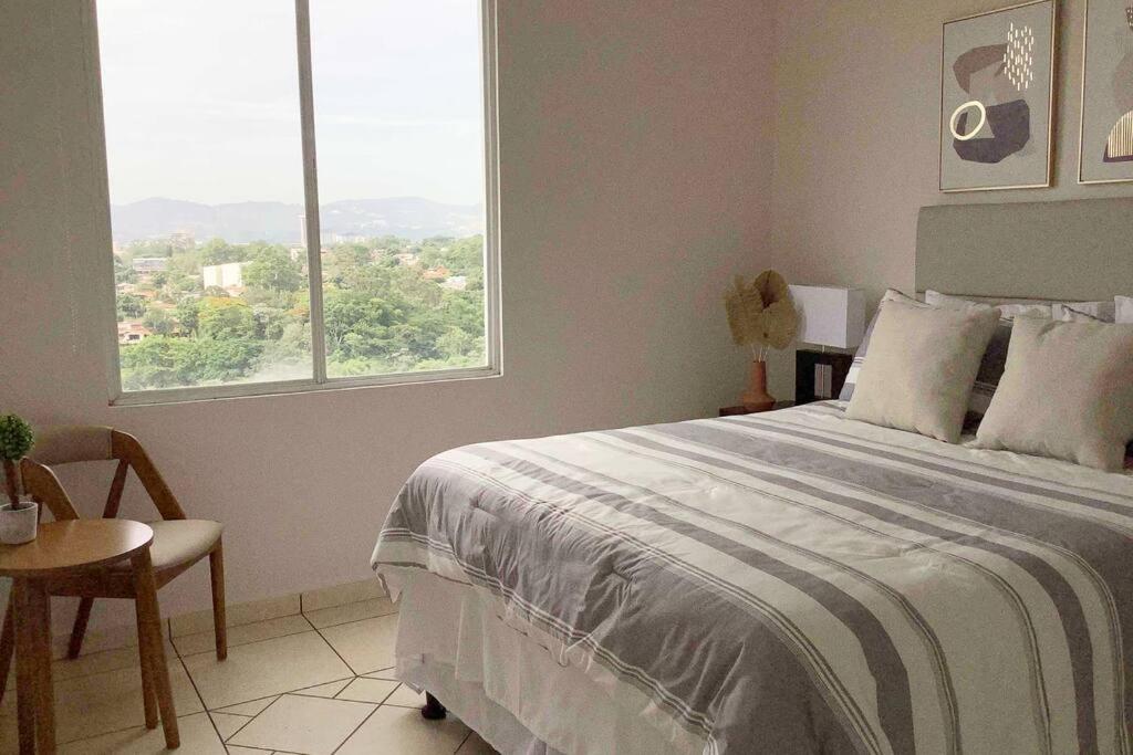 sypialnia z dużym łóżkiem i oknem w obiekcie Lovely 3Brm Apt w/City View&Pool @heart of Escalon w mieście San Salvador