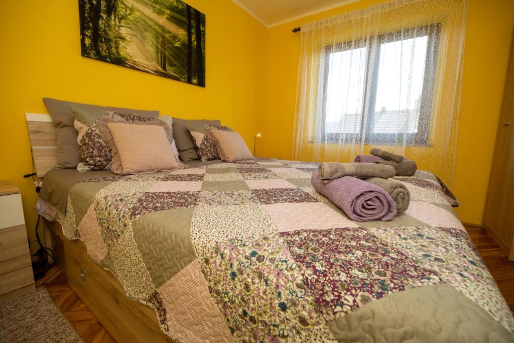 a bedroom with a bed with a quilt on it at apartman NOA in Fužine
