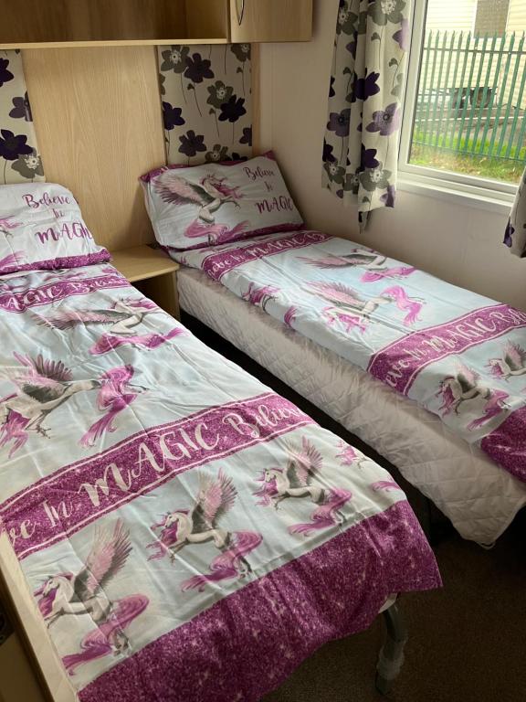 duas camas sentadas uma ao lado da outra num quarto em F 41 Hutleys Caravan Park em Saint Osyth