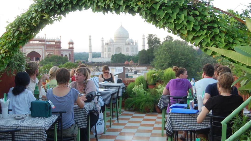 a group of people sitting at tables on a patio at Hotel Saniya Palace inn in Agra