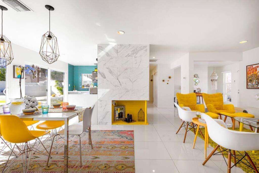 a living room with yellow chairs and a dining room at Amarillo House - Luxury Home with Pool & Spa in Palm Springs
