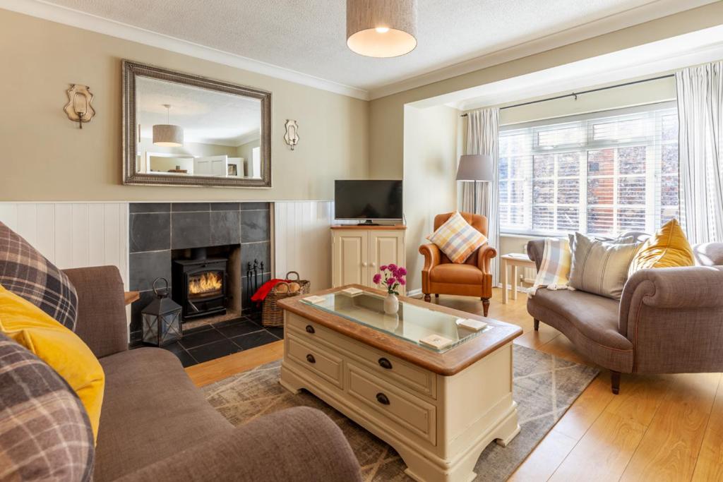a living room with a couch and a fireplace at Heron Cottage - Norfolk Cottage Agency in Castle Acre