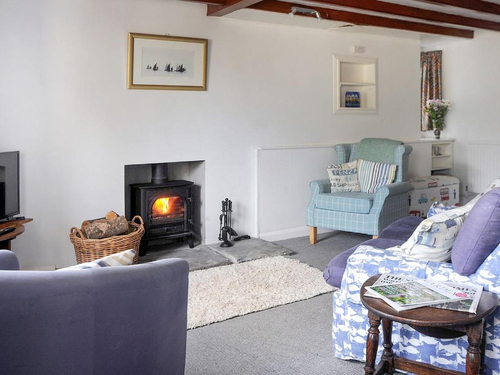 a living room with a couch and a fireplace at Tremar in Saint Martins Green