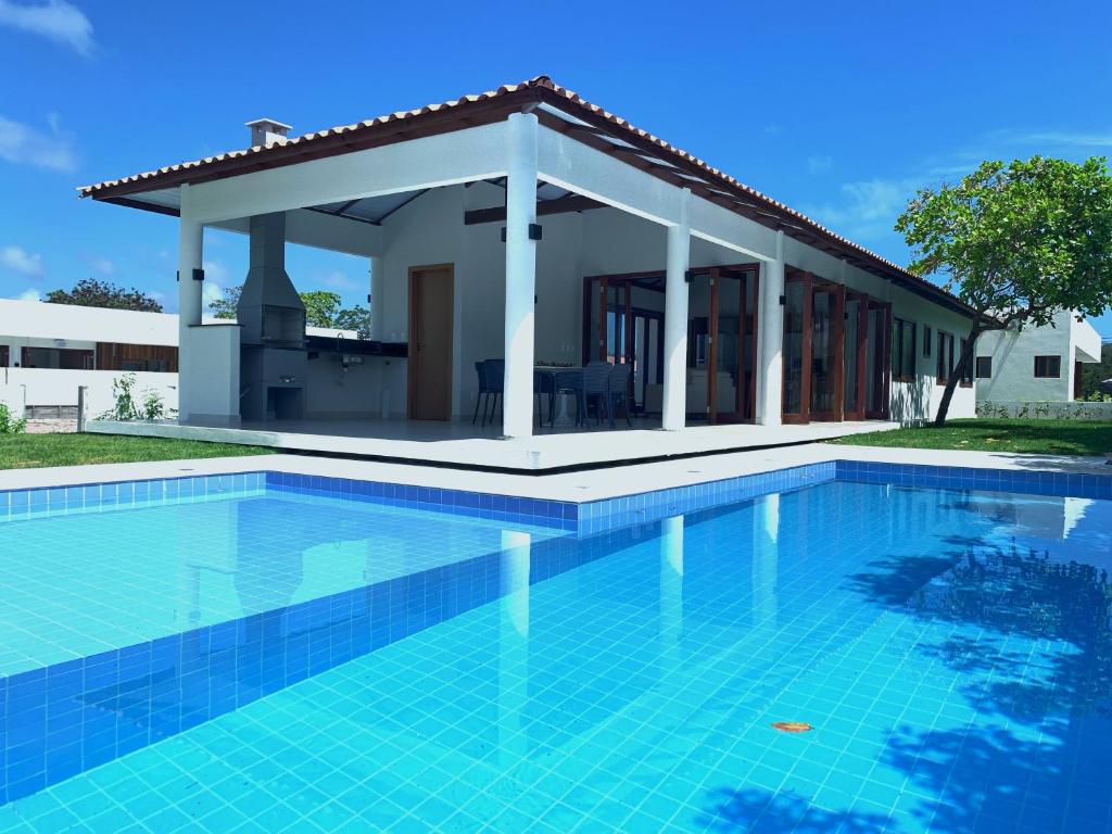 uma piscina em frente a uma casa com um gazebo em Casa do Bem - Deluxe 3 bedroom villa with pool. em Pipa