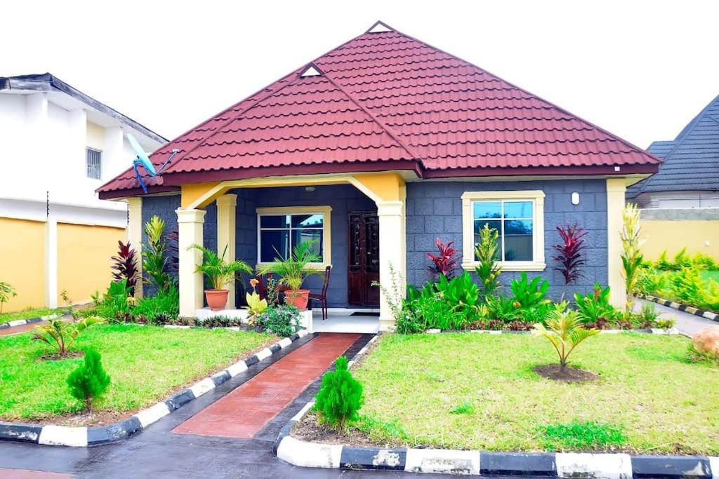 a small house with a red roof at Frankie’s Place: A spacious 4-bedroom home in Ondo