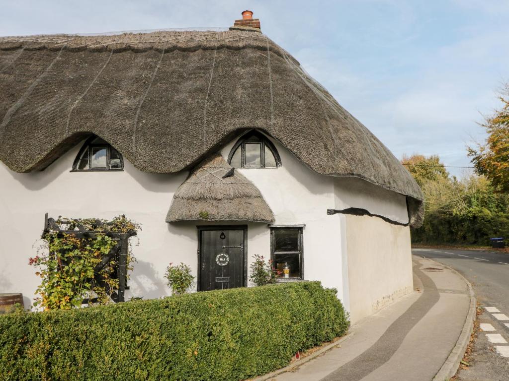 a thatched cottage with a thatched roof at 1 Peacock Cottage in Salisbury