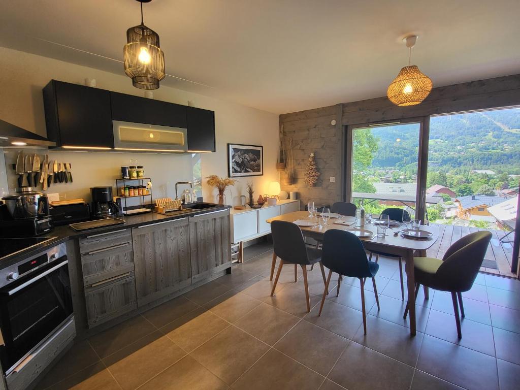 a kitchen and dining room with a table and chairs at Le Criou - 3 bedroom apartment 5 minutes walk to the village centre in Samoëns
