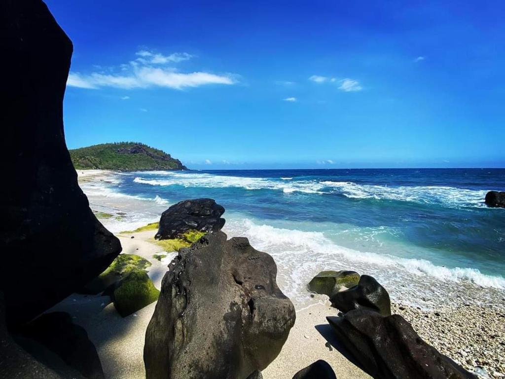 - une plage avec des rochers et l'océan dans l'établissement Villa Creole alamanda 2, à Petite Île