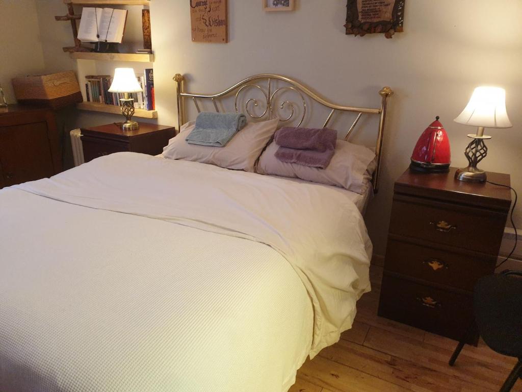 a bedroom with a bed with white sheets and purple towels at Creepy ole chapel in Inverness