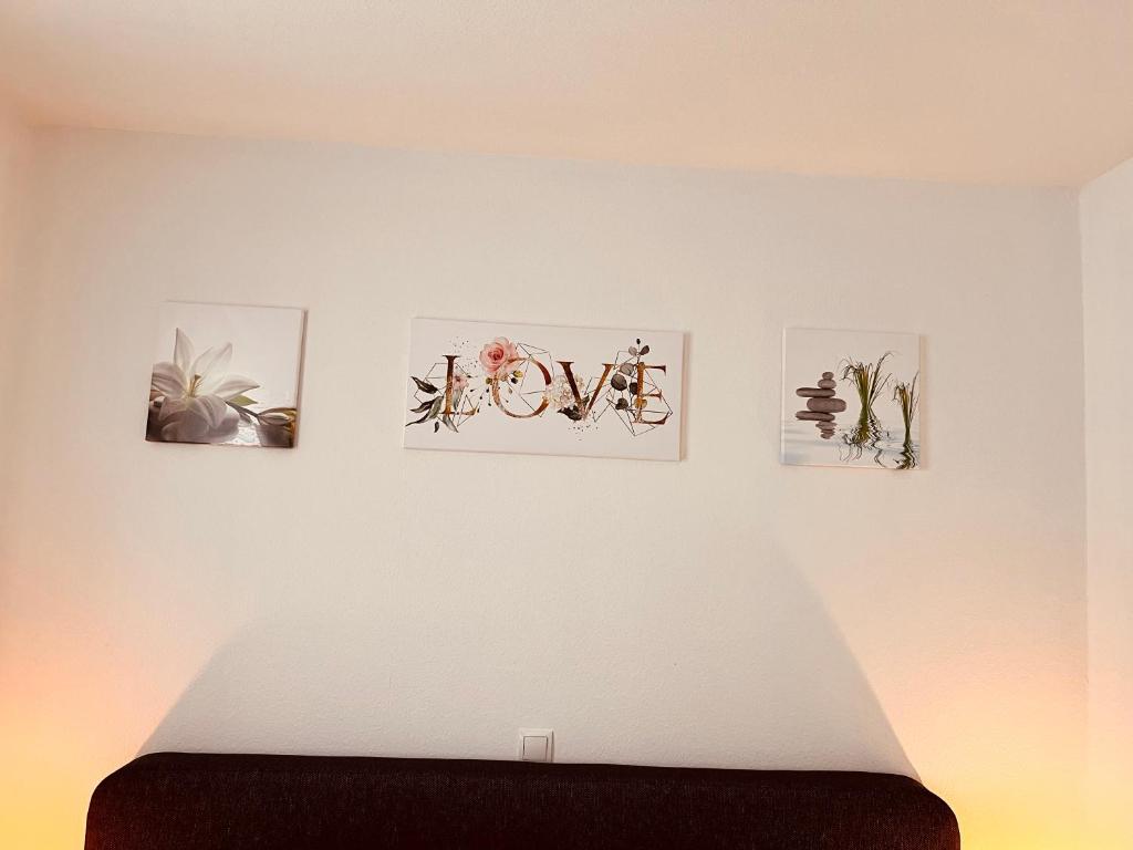 ein Schlafzimmer mit vier Bildern an der Wand in der Unterkunft Zentrale beautiful Apartment in Koblenz in Koblenz