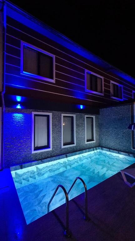 una piscina por la noche con luces azules en Villa Koyuncu, en Dalaman