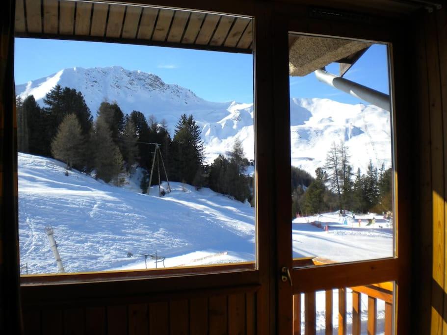 een raam met uitzicht op een met sneeuw bedekte berg bij Appt Plagne Village skis aux pieds - LES HAMEAUX 2 in Plagne Villages