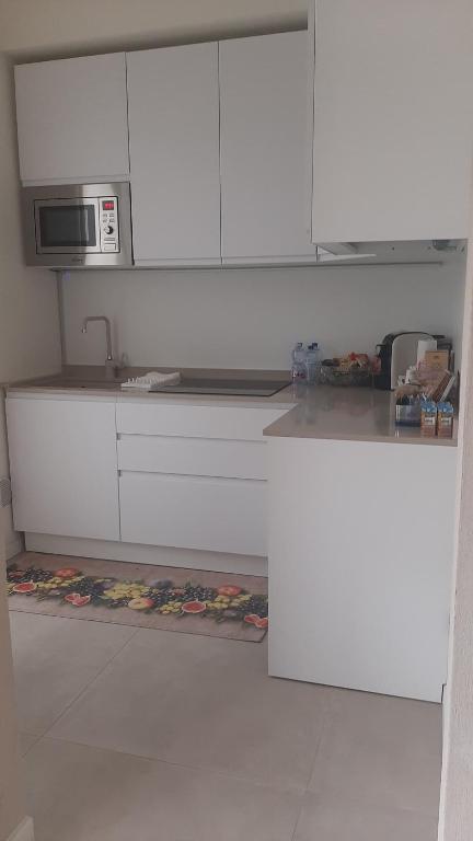 a kitchen with white cabinets and a microwave at Locazione turistica Corner 20 in Piacenza