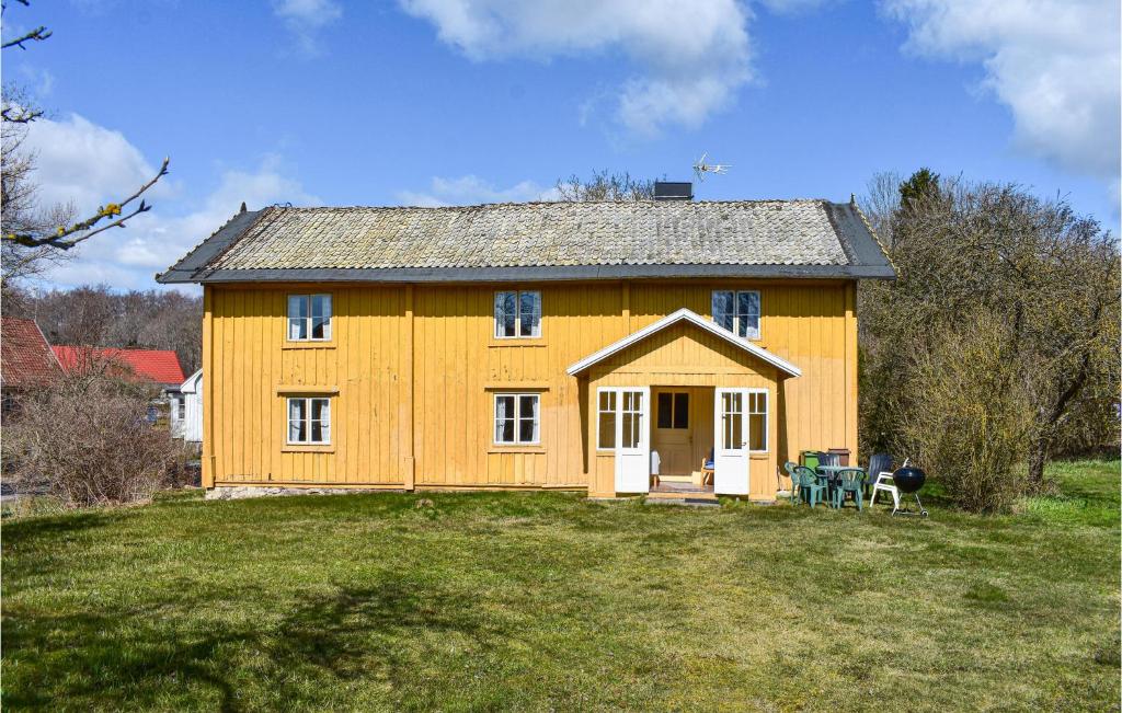 une maison jaune avec une table et des chaises devant elle dans l'établissement 3 Bedroom Beautiful Home In Ronneby, à Ronneby