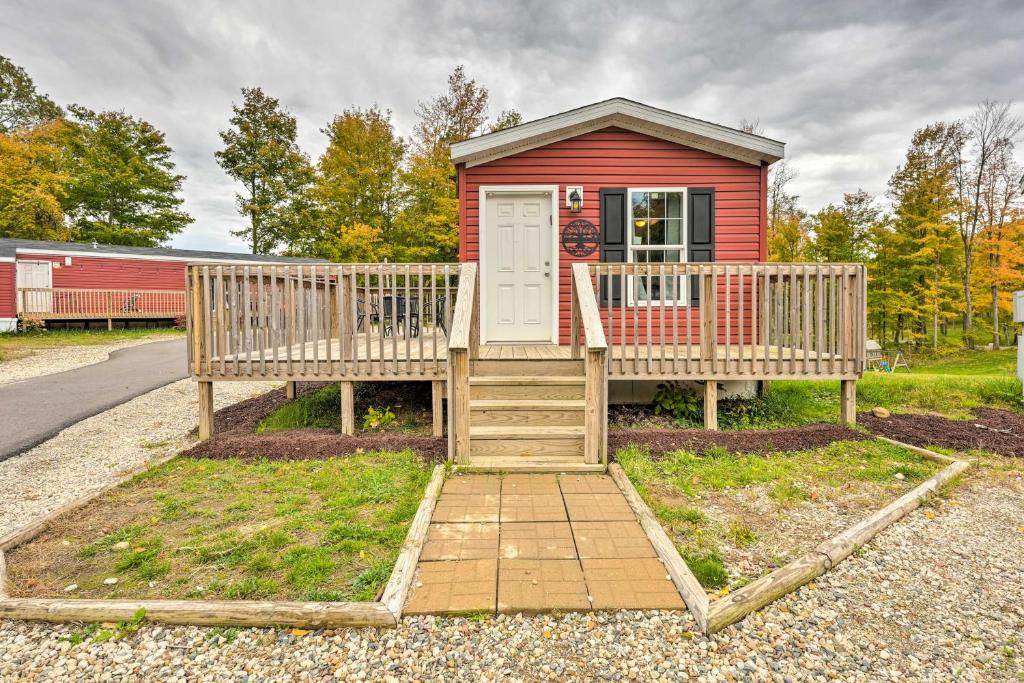 a small red house with a porch and a door at Cozy Cassopolis Retreat on Little Fish Lake! in Cassopolis