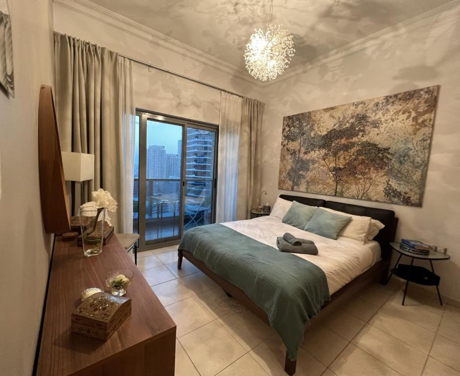 a bedroom with a bed and a large window at Fabolous Vacation Home in Dubai Marina in Dubai