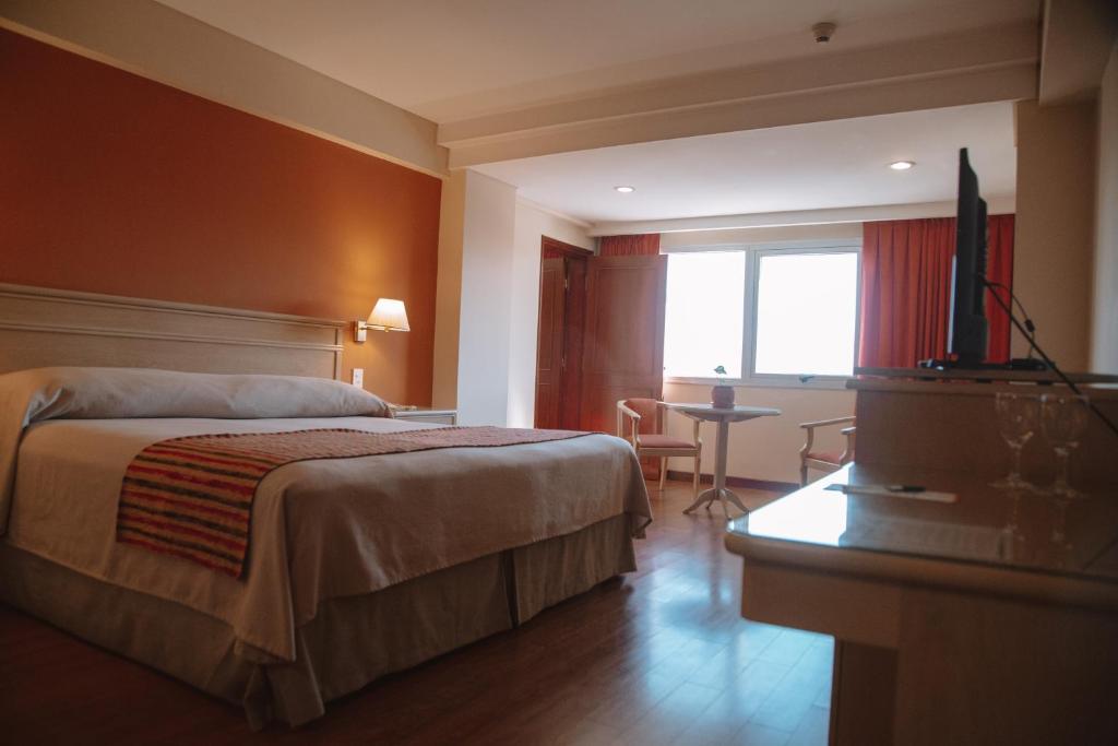 Habitación de hotel con cama y TV de pantalla plana. en Casa Real Hotel en Salta