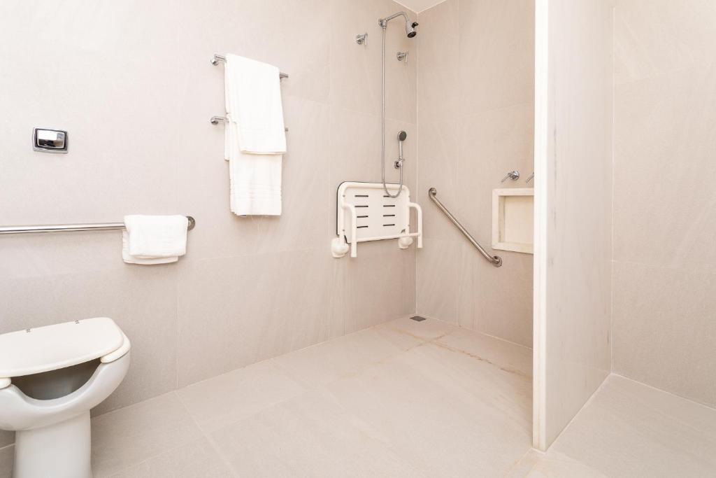 a white bathroom with a toilet and a shower at Mar Ipanema Hotel in Rio de Janeiro