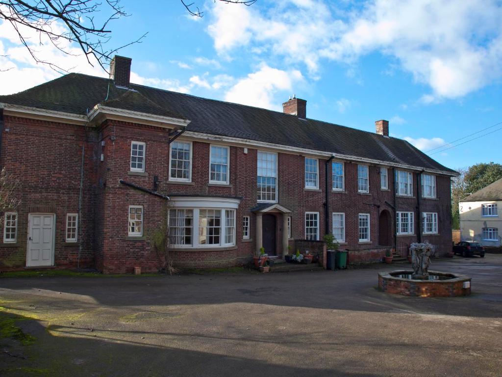 a large brick building with a fountain in front of it at Boothorpe Hall in Swadlincote