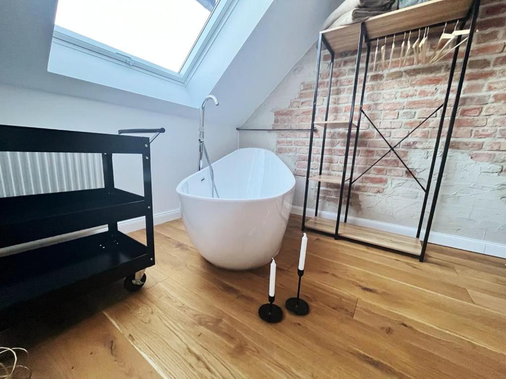 a bath tub sitting on a wooden floor in a room at Ferienloft Ottos Werkstatt mit Saunafass in Dannenfels