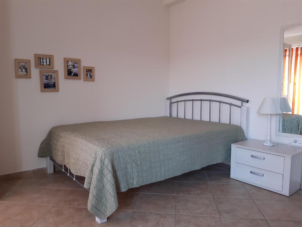 um quarto com uma cama e uma mesa com um candeeiro em Suntime apartment em Tivat