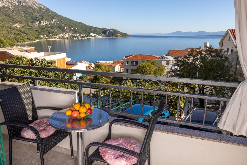 a table on a balcony with a view of the water at Apartmani Nina & Mili in Igrane