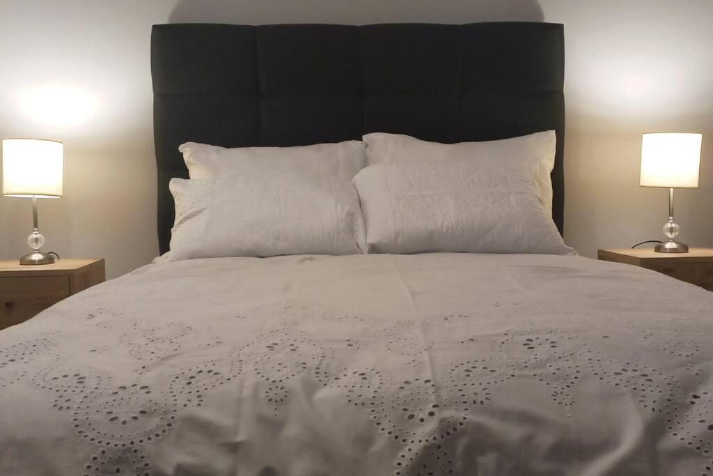 1 dormitorio con 1 cama con sábanas blancas y 2 lámparas en Gorgeous Private Studio LIMA-Own Bathroom-Near Airport, en Lima