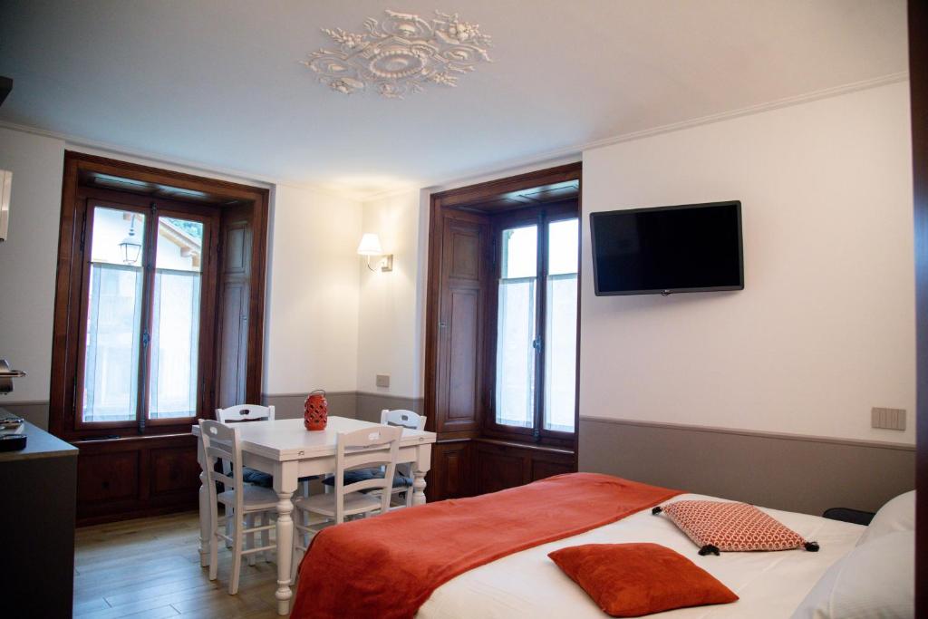 a bedroom with a bed and a table and a television at Residence Kalip&egrave; in Alagna Valsesia