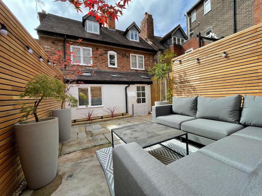 a patio with a couch and a table and a house at Georgian 3 bed house in historic town centre in Shrewsbury