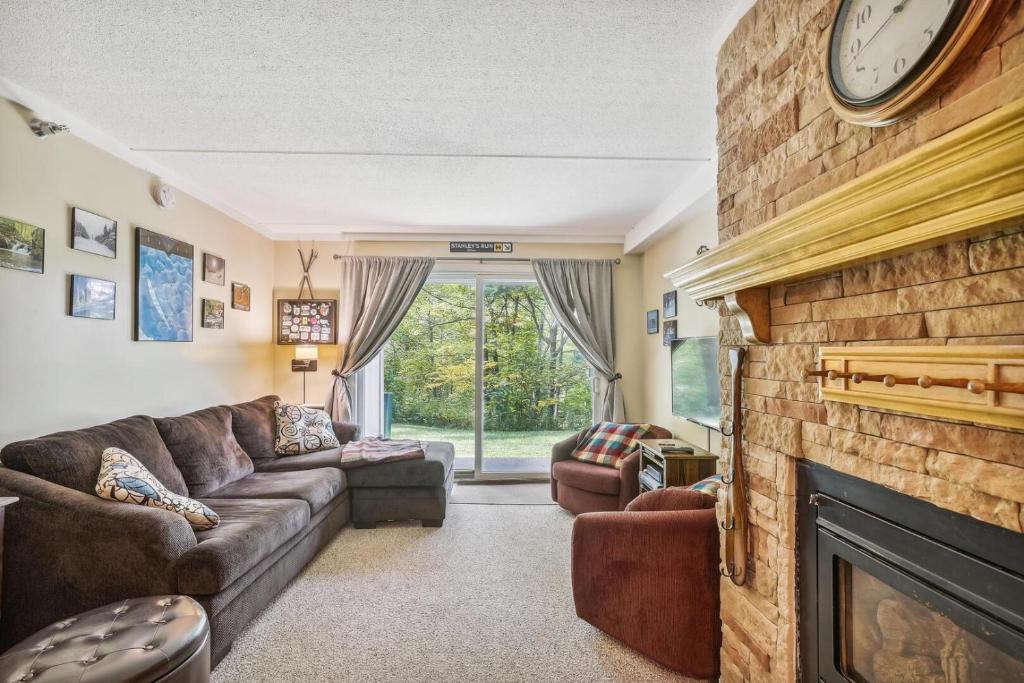 sala de estar con sofá y chimenea en Whiffletree I1, en Killington