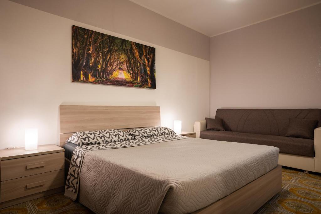 a bedroom with a bed and a couch at Loft in Centro con Camino - Sestola in Sestola