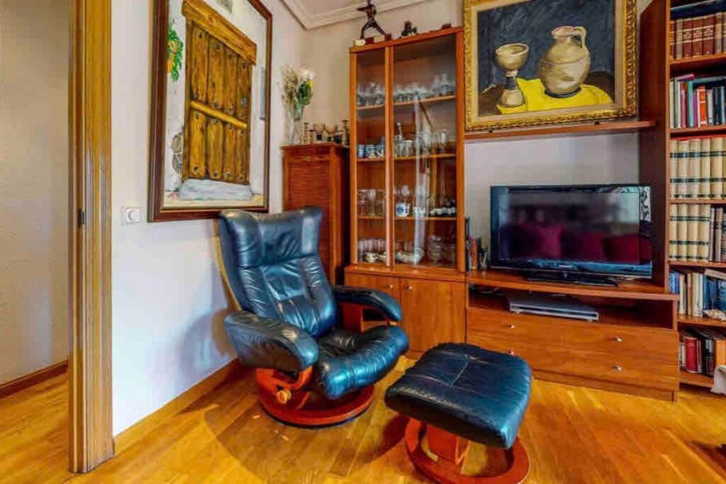 a living room with a leather chair and a television at La Casa del impresor in Avila