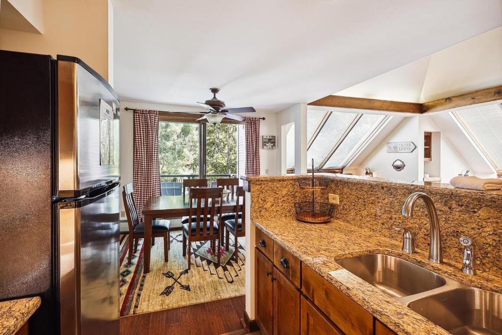 a kitchen with a stainless steel refrigerator and a table at Sunrise Highlander L2 in Killington