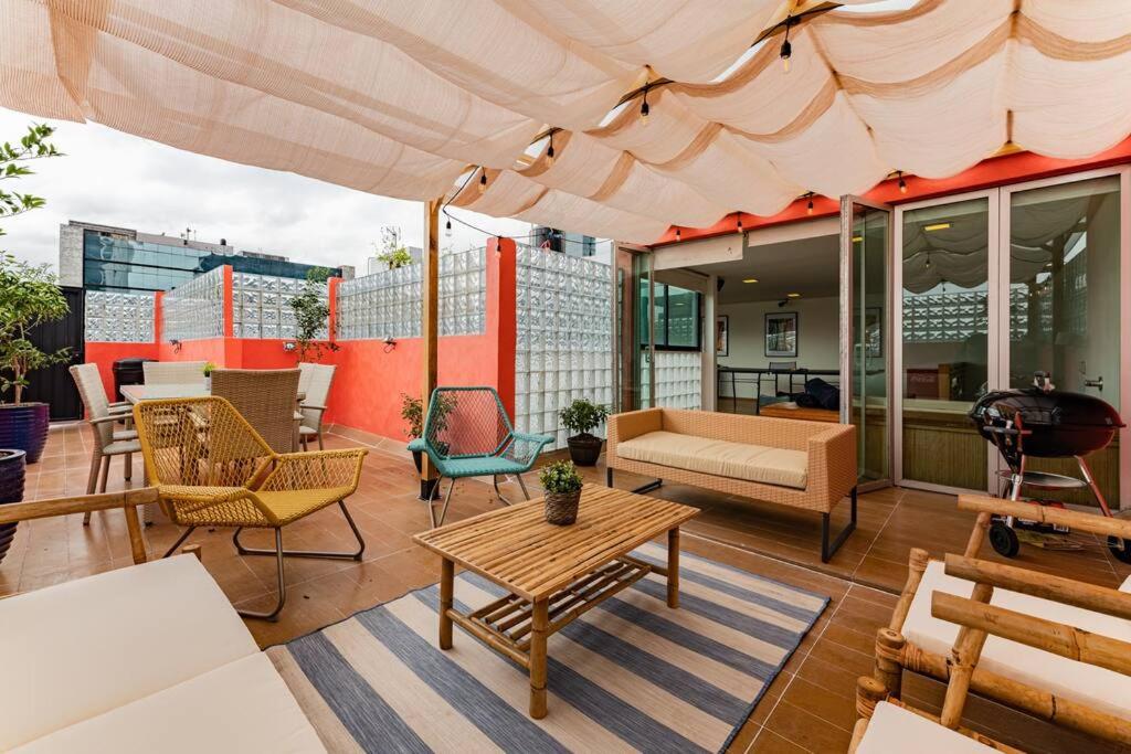 un patio con muebles y una sombrilla en un edificio en Stylish apartment with private roof top & jacuzzi, en Ciudad de México