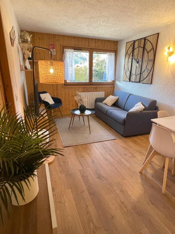 un salon avec un canapé bleu et une table dans l'établissement Au Petit Flocon - Appartement 3 pièces, central et proche pistes - parking privé et wifi, à Megève