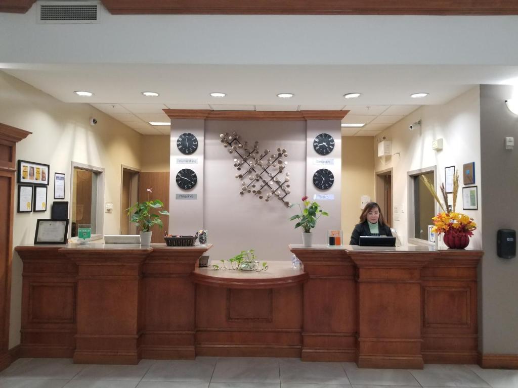 a woman sitting at a counter in a waiting room at Merit Hotel & Suites in Fort McMurray